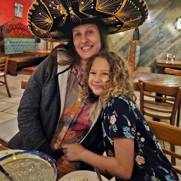 A woman in a sombrero and a young girl smiling at Chaparral Mexican and Cuban Restaurant.