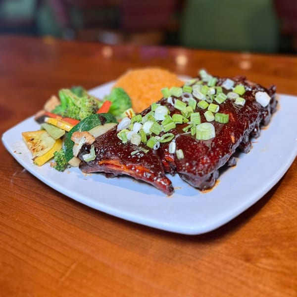 Chaparral Mexican and Cuban Restaurant's ribs with rice and mixed vegetables on a white plate.